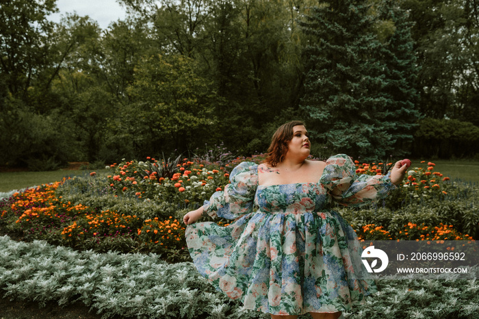 portrait of a plus size woman holding a macaron in a garden