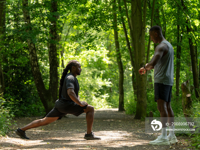 Two men stretching in forest