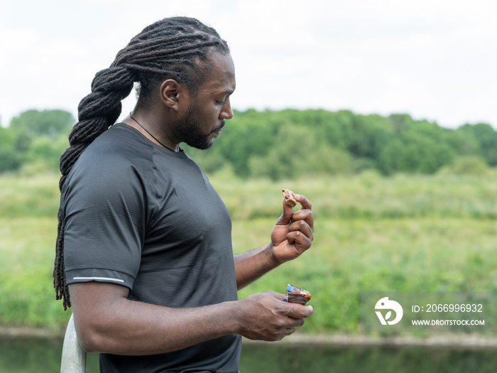 Man eating protein bar during workout