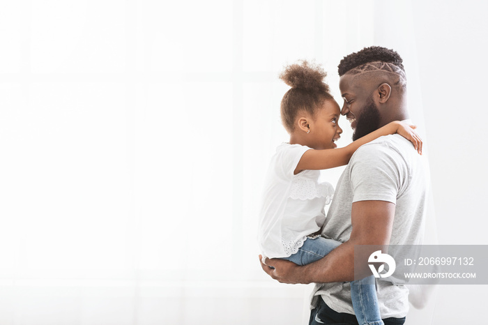 Loving african father carrying his preschool daughter over white background