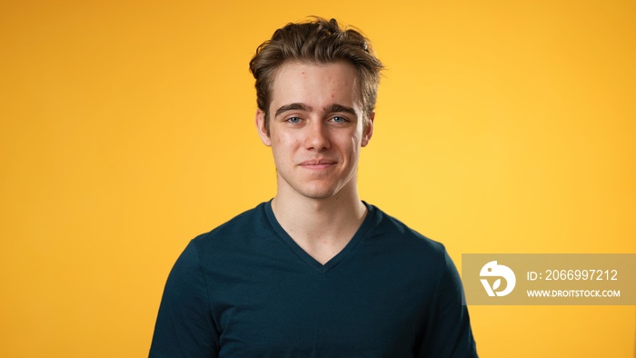 Portrait of smiling happy young hipster man 20s isolated on solid yellow background with copy space in studio