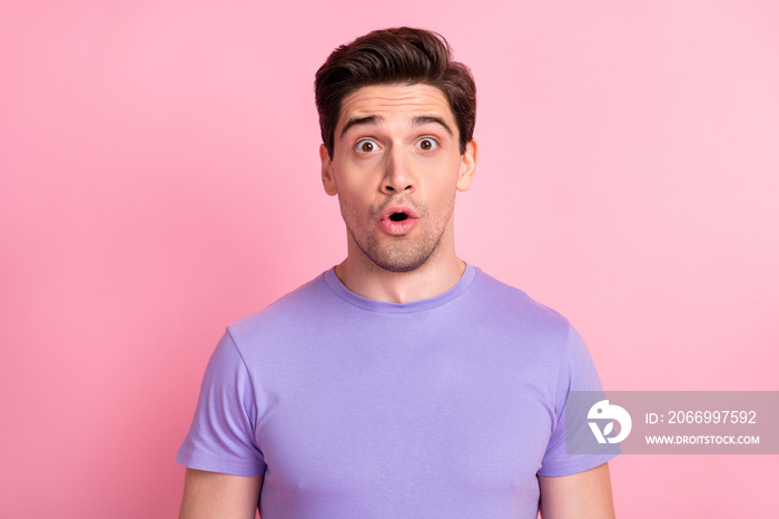 Portrait of attractive amazed guy wear violet tshirt reaction pout lips isolated over pink pastel color background