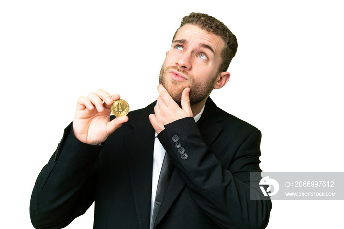 Young business blonde man holding a Bitcoin over isolated chroma key background having doubts