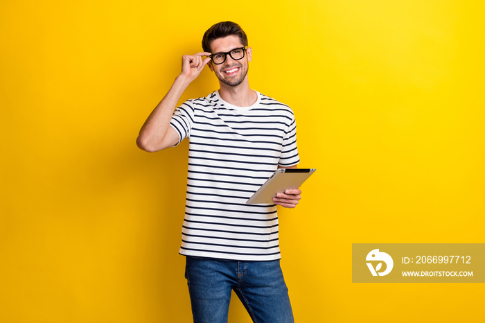 Photo of cheerful successful person hold tablet hand touch glasses isolated on yellow color background