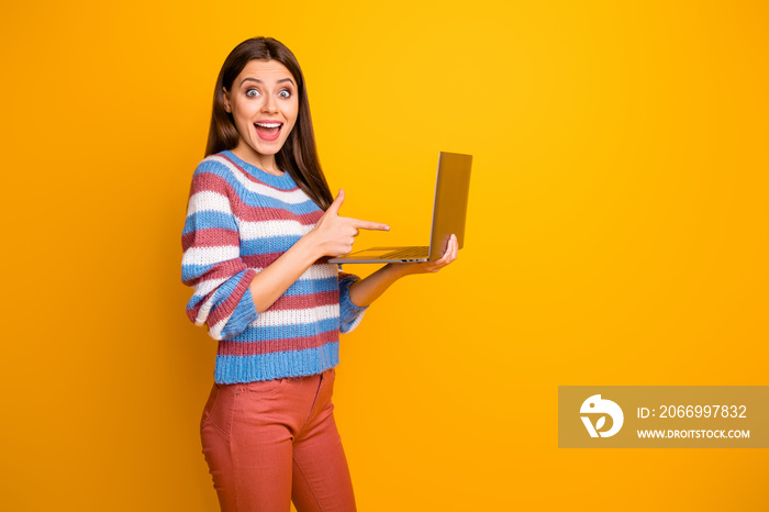 Portrait of her she nice attractive amazed stunned glad cheerful cheery brown-haired girl holding in hands laptop showing shop sale isolated over bright vivid shine vibrant yellow color background