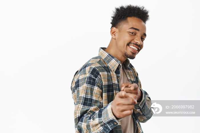 You got this. Smiling confident african american man, looking satisfied, praise and compliment person, pointing finger at camera, inviting or congratulating someone, standing over white background