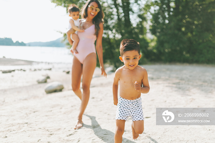 A mother and her children together at the beach in summer.