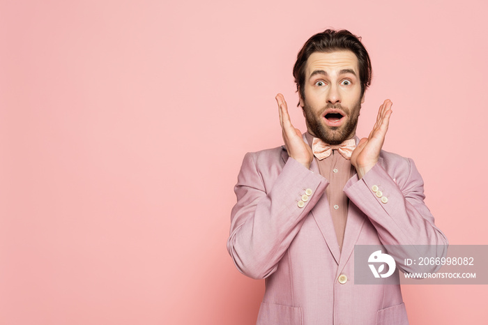 Shocked host of event looking at camera on pink background