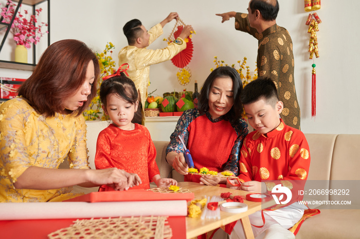 Big family making decorations for celerating Lunar New year at home