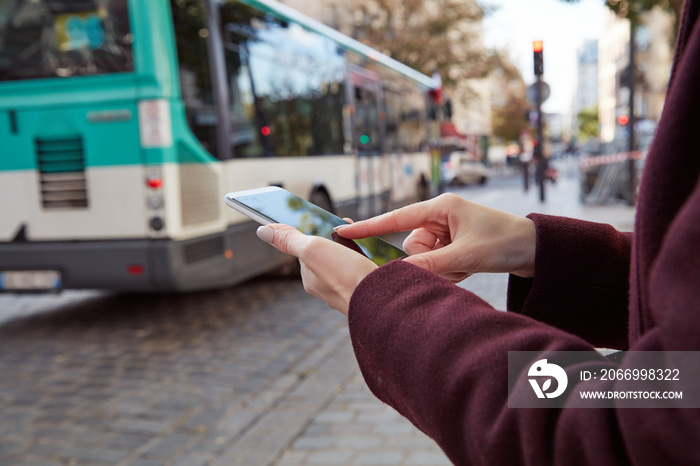 Woman using smartphone in the streets of Paris, France.