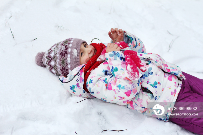 A little girl is playing in the snow