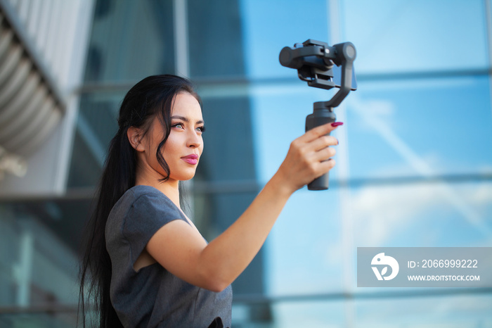 Blogger girl shoots a video about traveling on an electronic stabilizer.