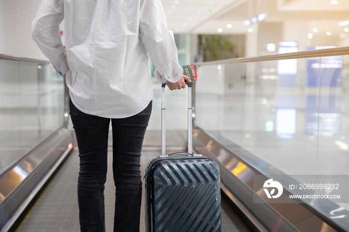 Back view of woman moving using escalator at airport