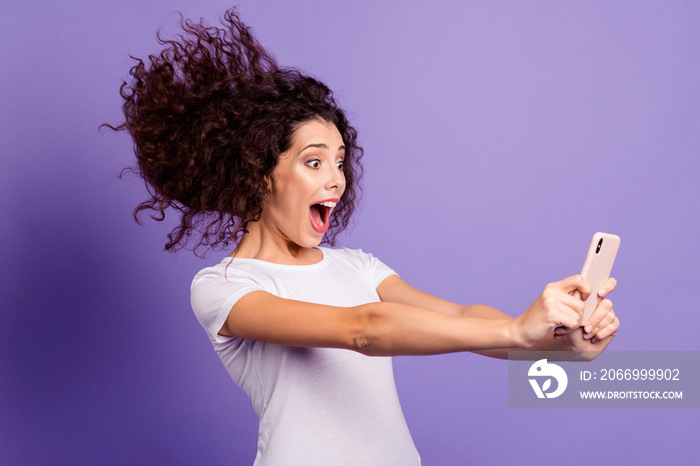 Portrait of her she nice attractive lovely cheerful funny crazy wavy-haired lady holding in hand cellular making taking selfie isolated on bright vivid shine violet pastel background