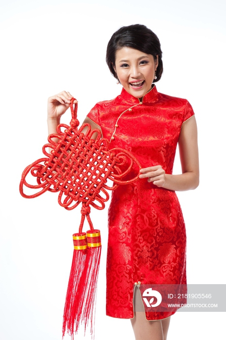 棚拍节日身穿红色旗袍的年轻女人拿着中国结