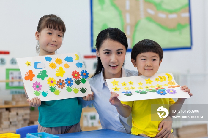 幼儿园女老师辅导儿童做手工