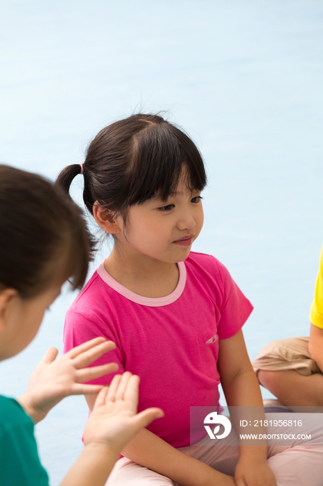 幼儿园儿童盘着腿坐在地板上