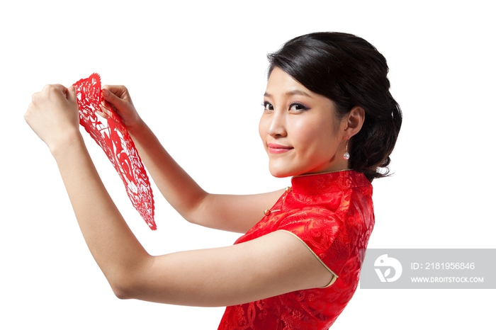 棚拍节日身穿红色旗袍的年轻女人拿着福字剪纸