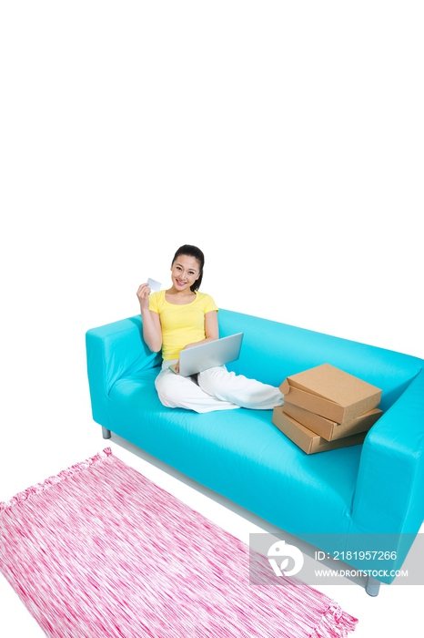 棚拍年轻女人坐在沙发上上网购物
