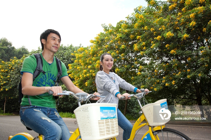 年轻大学生在校园里骑车