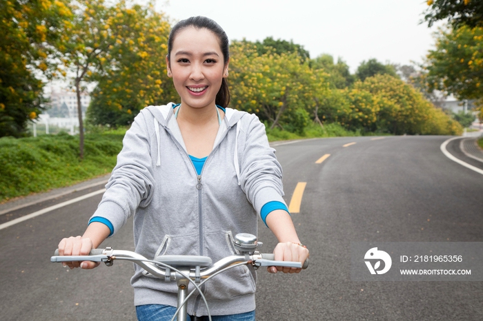 一个年轻女大学生在校园里骑车