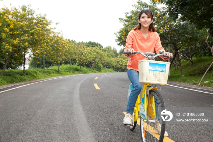 一个年轻女大学生在校园里骑车