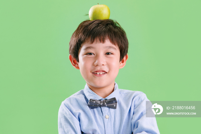 小男孩头上顶着一个苹果