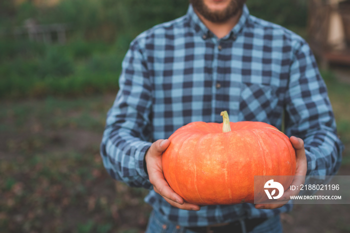 guy holding a pumpkin in her hands close-up