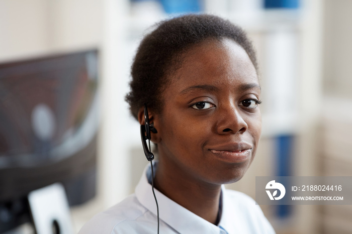 Head and shoulders portrait of smiling African-American woman wearing headset and looking at camera 