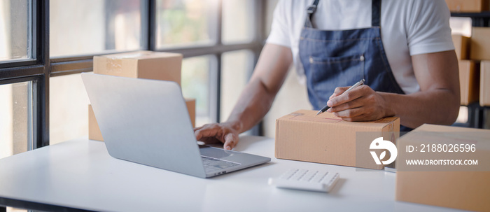 Online shopping young start small business in a cardboard box at work. The seller prepares the deliv