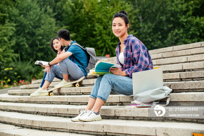 快乐的大学生坐在台阶上学习