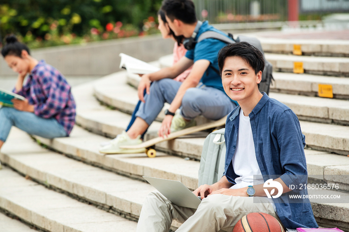 快乐的大学生坐在台阶上学习