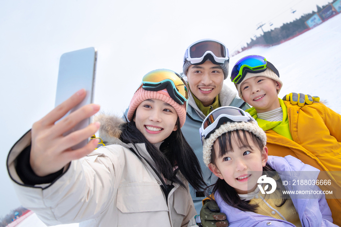 滑雪场上一家四口搂在一起自拍