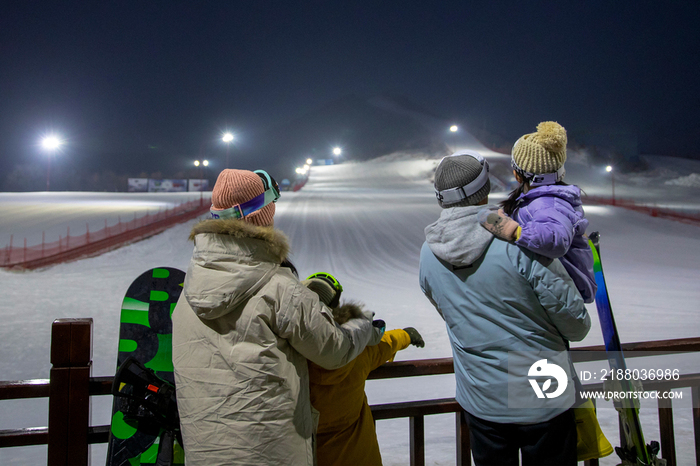 滑雪场看夜景的一家四口的背影