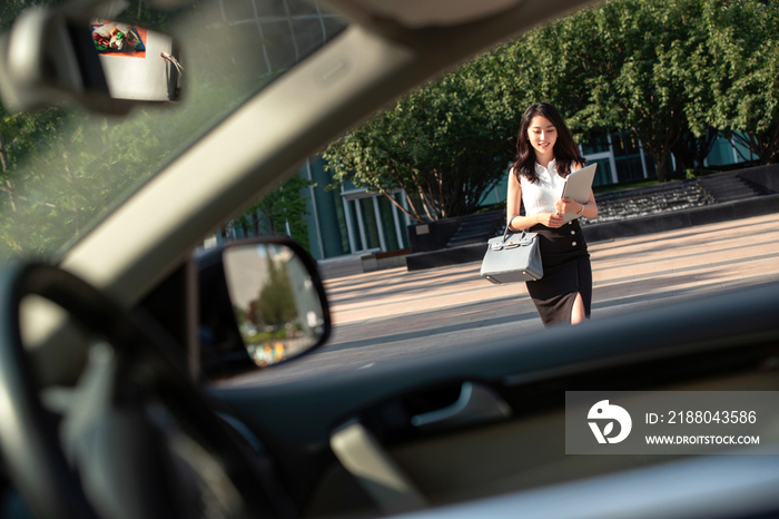 优雅的青年女人走向汽车