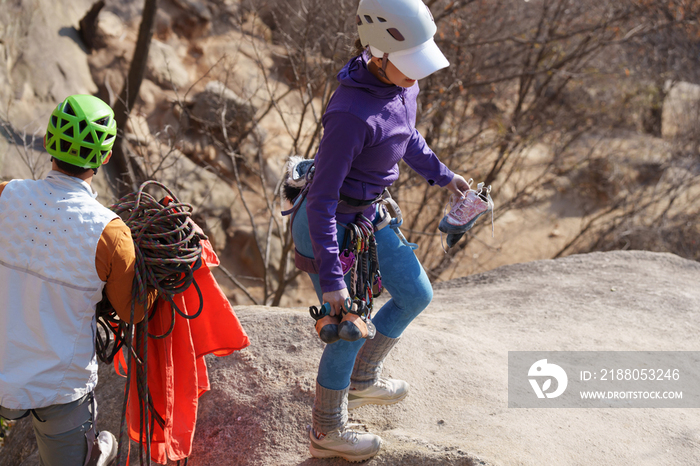 青年登山者伴侣调整登山设备
