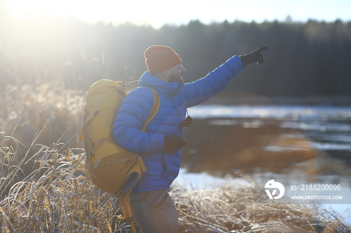 tourist view from the back / a man with a backpack goes through the winter forest, view of the outgoing