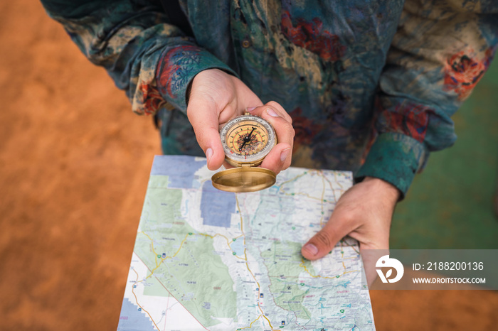 Crop traveler navigating with compass and map