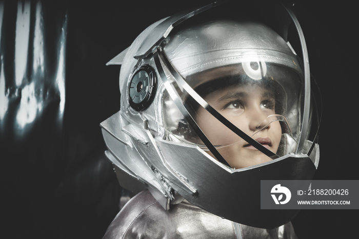 Boy playing to be an astronaut with space helmet and metal suit