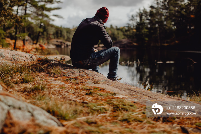 Homme contemplant la vue sur le lac à l’automne