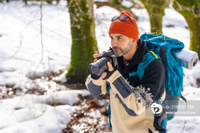 Photographer enjoying taking photos in winter in a snowy forest