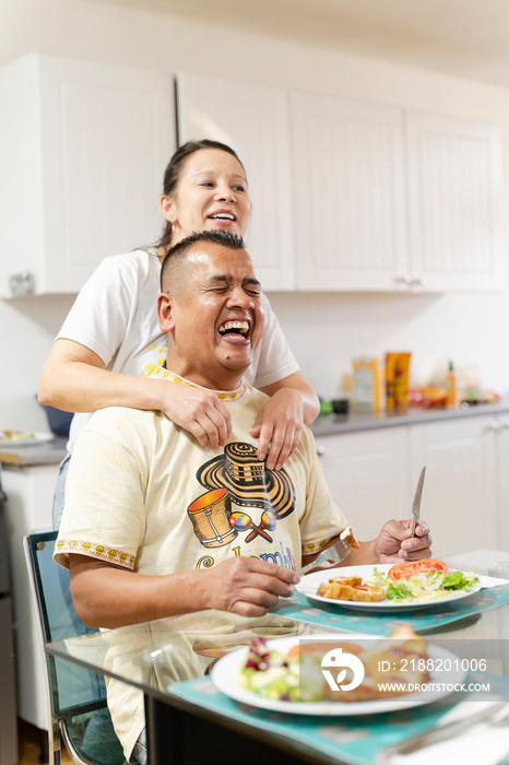 Couple enjoying lunch in domestic kitchen