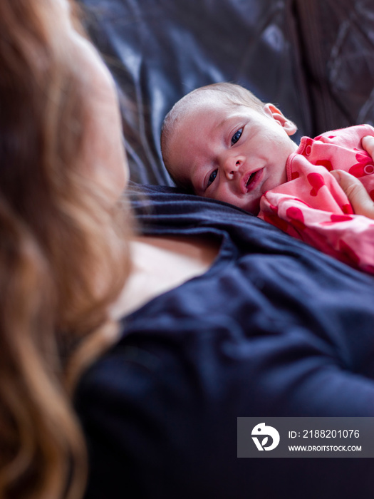 Mother lying on sofa with infant daughter