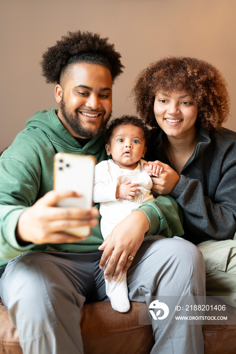 Family with baby girl taking selfie at home