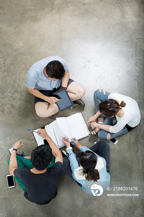 Group sitting on floor around folder