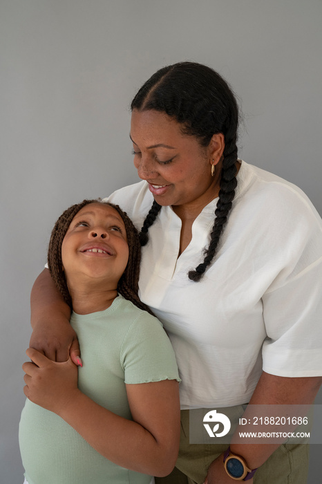 Mother embracing and looking at daughter (6-7)