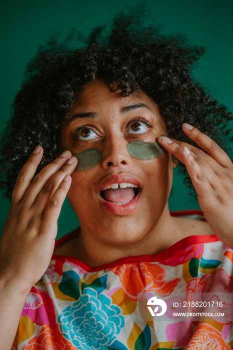 closeup of a plus size black person applying cooling eye pads