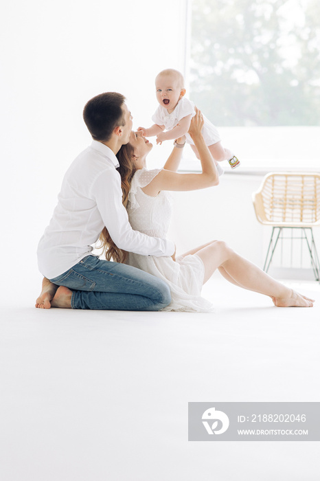 Happy parents sit and play with their baby boy.