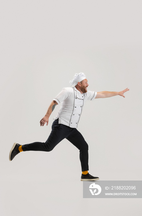 Portrait of cook, chef man in uniform running to kitchen isolated on white background. Concept of job, occupation, humor.