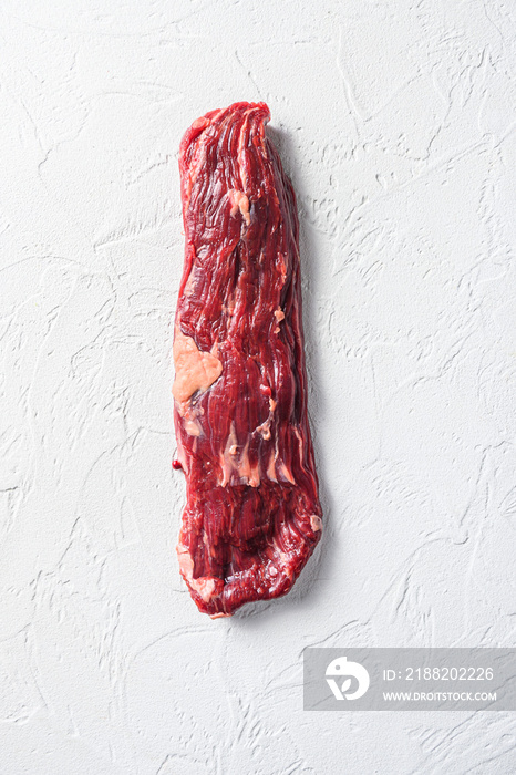 Raw skirt, machete steak on a white stone background vertical